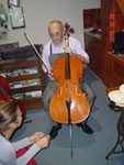 Stevan Rakić svira violončelo u svojoj radnji u Novom Sadu